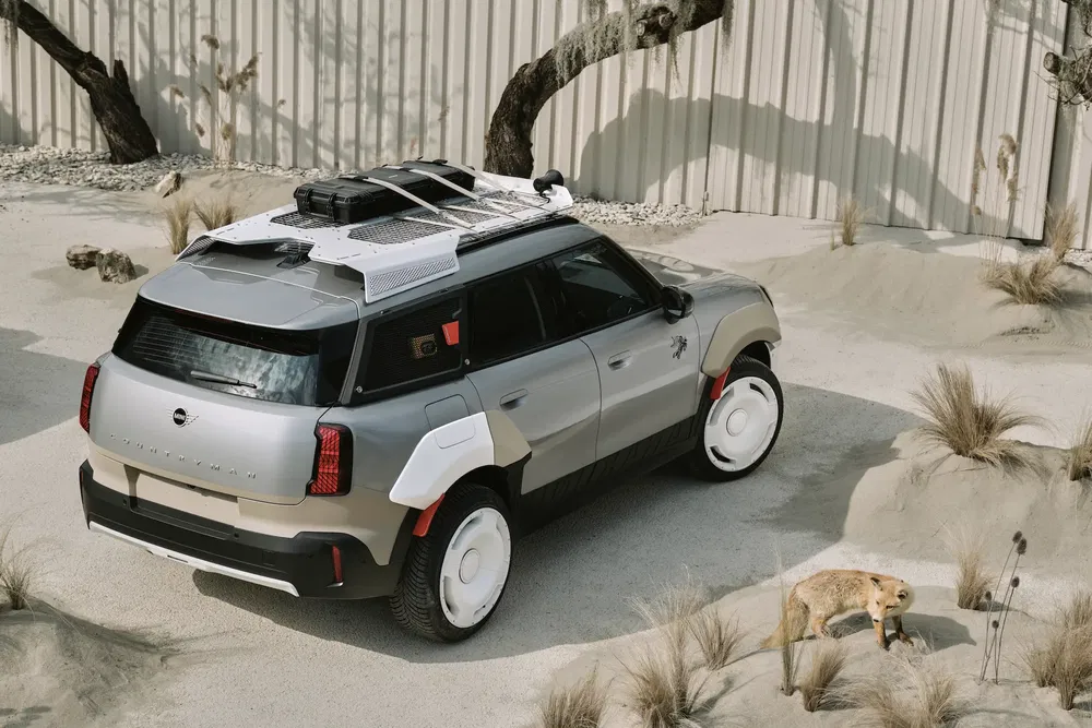 Mini Countryman tout-terrain gris avec système de portage sur le toit, paysage désertique.