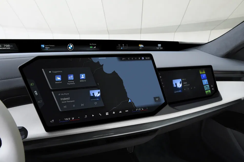 Interieur van BMW-auto met moderne digitale schermen en navigatie-interface.
