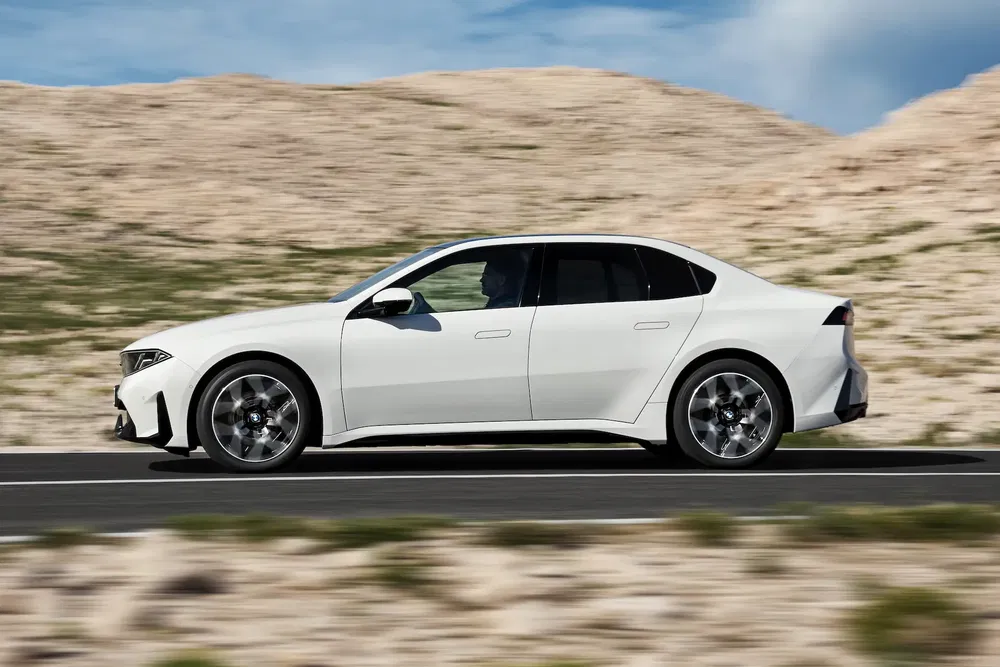 Peugeot 508 blanc roulant sur une route avec paysage désertique en arrière-plan.