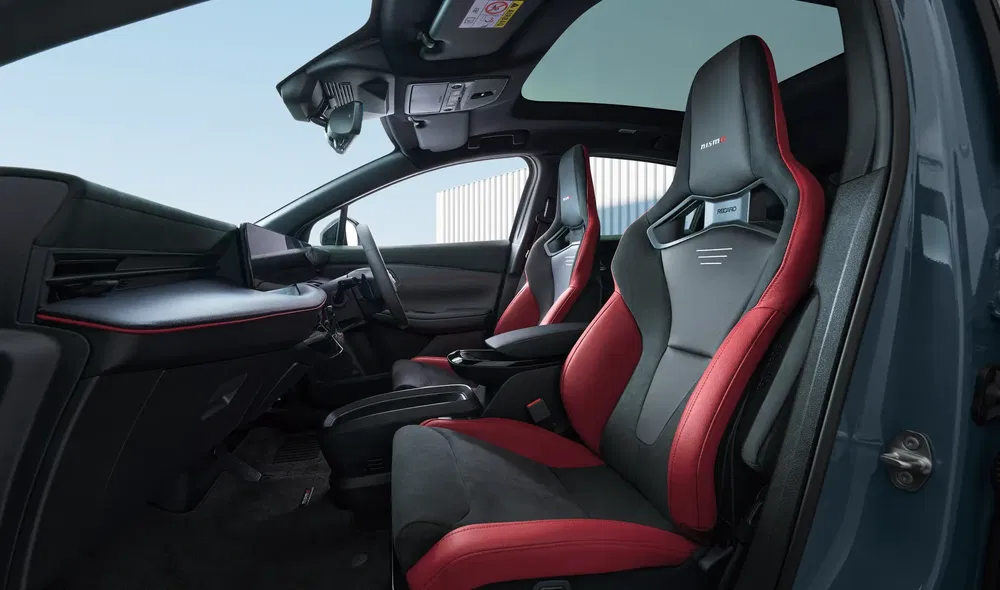 Intérieur de voiture sportive, sièges baquets rouge et noir, design moderne et technologique.