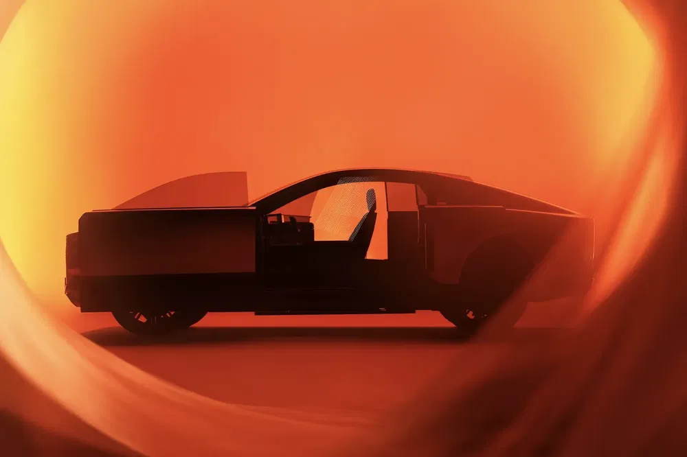Profil du Tesla Cybertruck en silhouette sombre sur fond orange vibrant.