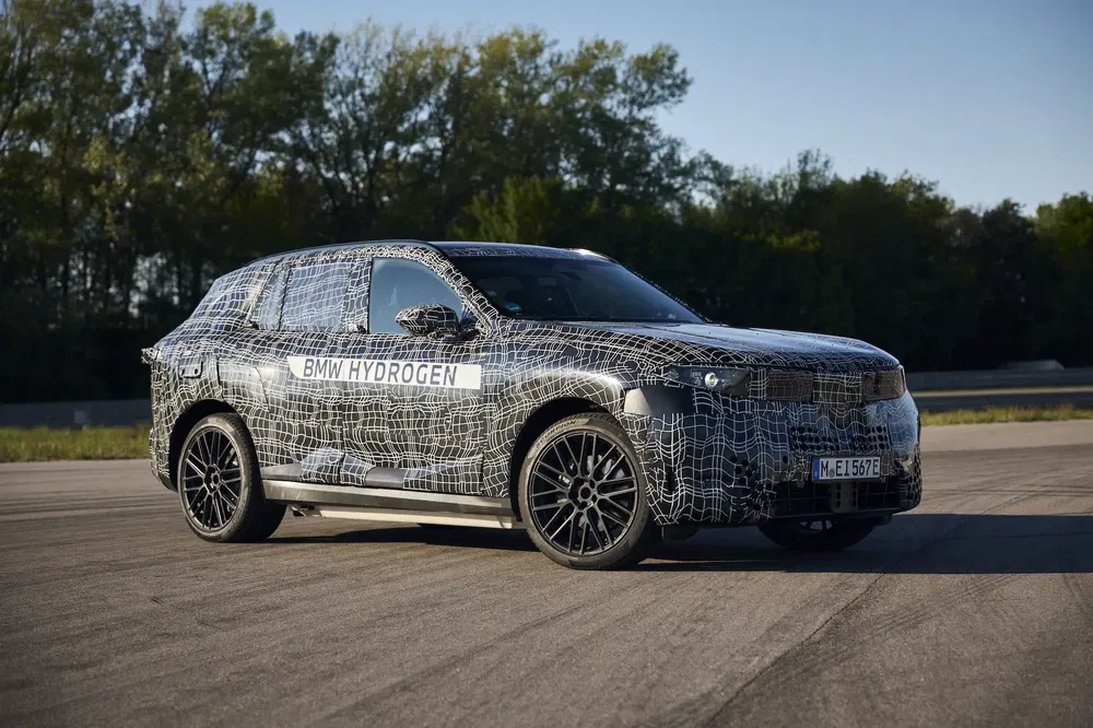 Prototype BMW Hydrogen camouflé sur piste d'essai, mettant en avant l'innovation automobile durable.
