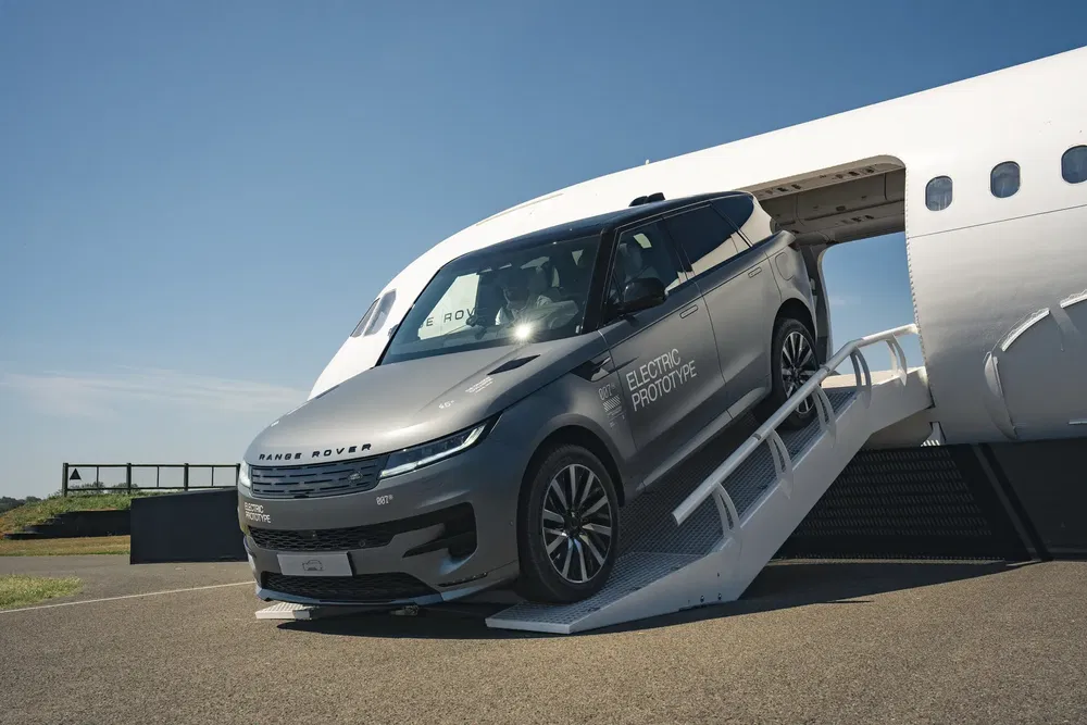 {"fr":"Prototype électrique Range Rover sortant d'un avion, soulignant l'innovation automobile moderne.","nl":"Elektrische prototype van Range Rover verlaat een vliegtuig, benadrukkend moderne automobielinnovatie."}