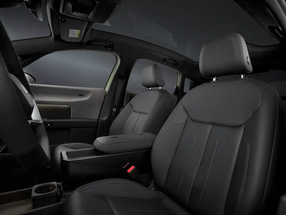 Intérieur de voiture moderne avec sièges en cuir noir et toit panoramique.