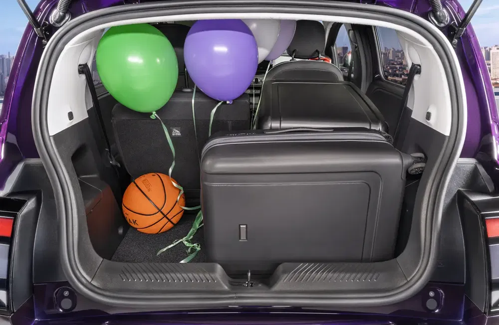 Coffre d'une voiture violet avec ballons et ballon de basket, sièges arrière rabattus.