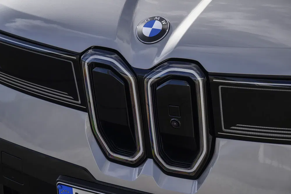 Gros plan sur la calandre de la BMW iX, logo emblématique visible.
