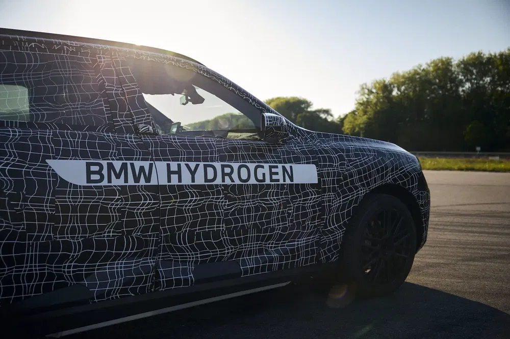 Prototype BMW à hydrogène sur piste d'essai, entouré d'arbres en arrière-plan.