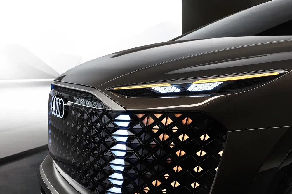Gros plan de l'avant d'une Audi avec des phares LED modernes et une calandre distinctive.