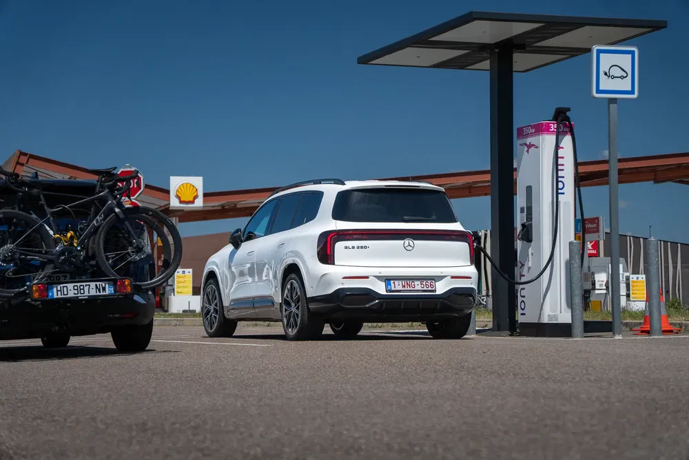Mercedes EQB 300 blanc en charge à une borne Ionity avec vélos à l'arrière-plan.