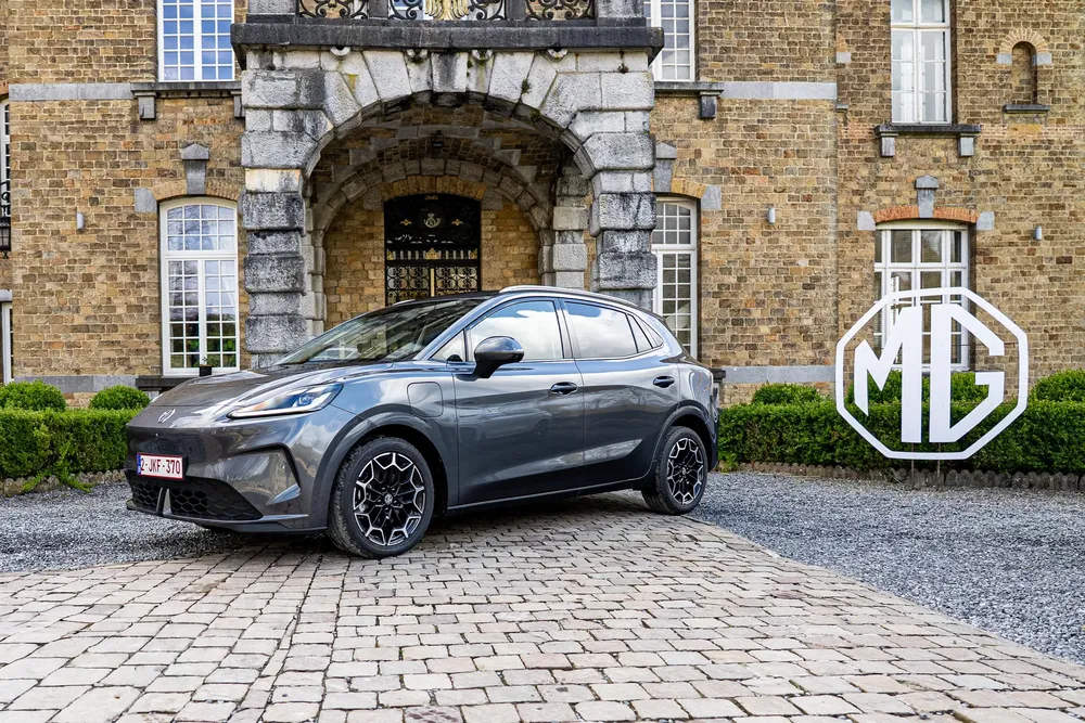 {"fr":"MG électrique stationnée devant un bâtiment historique, logo MG en arrière-plan.","nl":"Elektrische MG geparkeerd voor historisch gebouw, MG-logo op de achtergrond."}