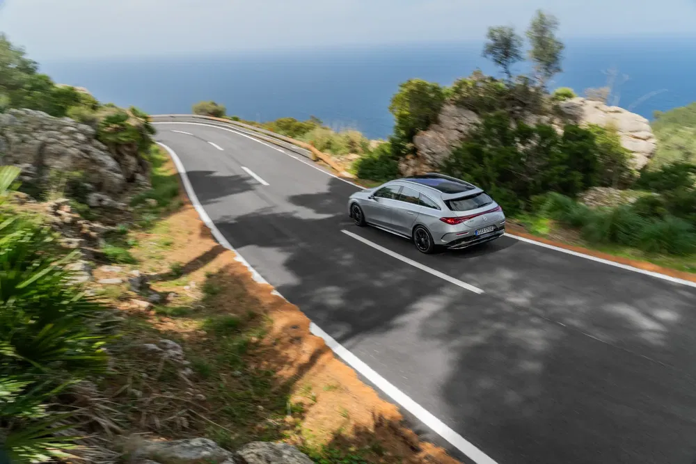 Mercedes-Benz CLA 2024 argent sur route côtière sinueuse avec vue sur la mer.