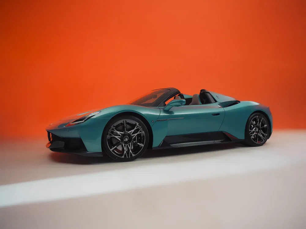 Blauwe Maserati MC20 Cielo tegen een oranje achtergrond, elegante en sportieve styling.