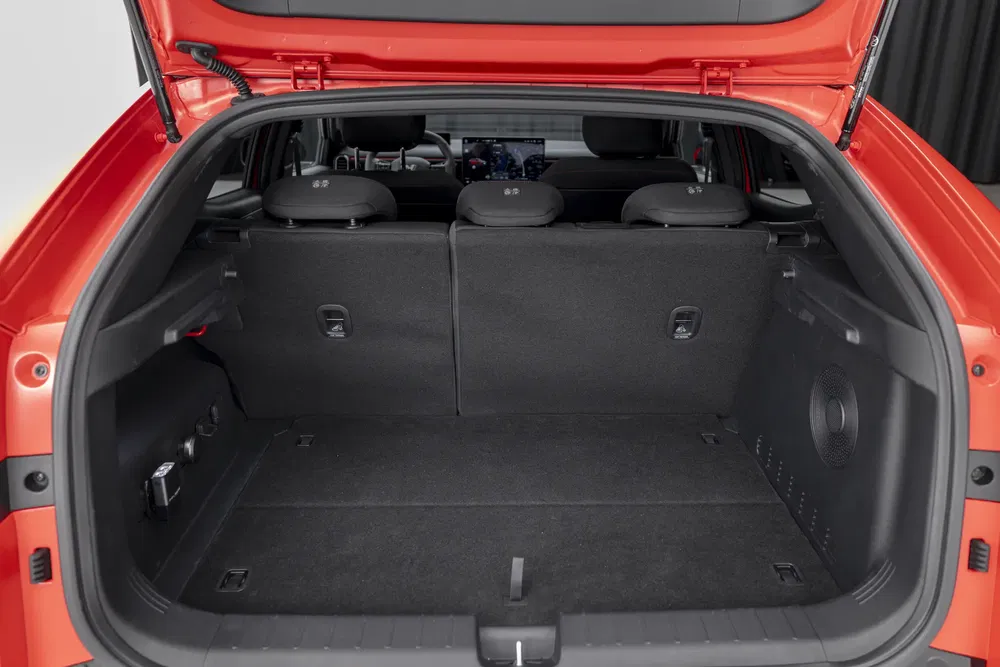 Coffre spacieux d'une Kia EV6 rouge avec sièges arrière rabattables.