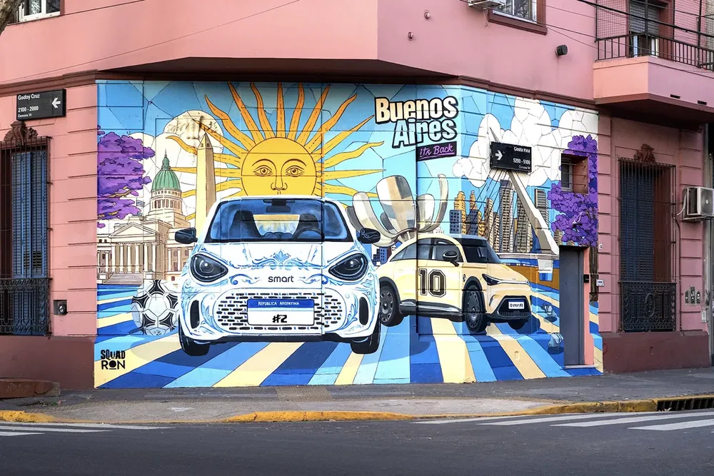 Kleurrijke muurschildering in Buenos Aires met Smart en Mercedes auto's, zonnesymbolen.
