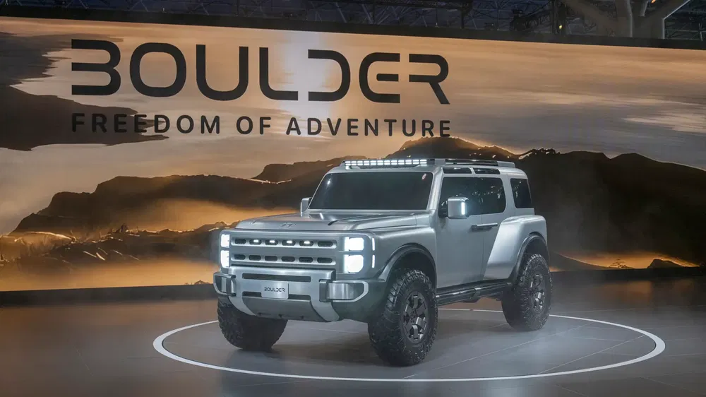 Concept car Boulder tout-terrain exposé, fond aventure paysagère suggestif.