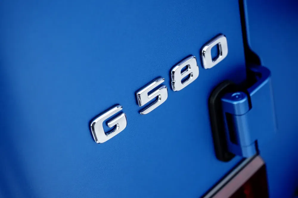 Détail du badge Mercedes G 580 sur une carrosserie bleue vibrante.