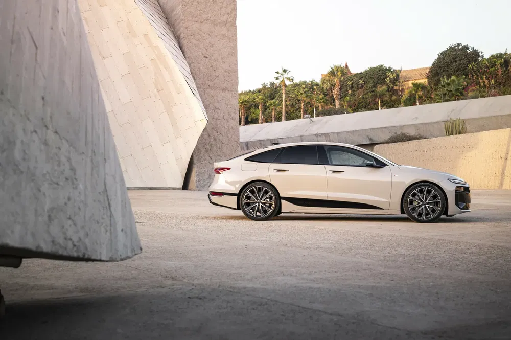 Voiture électrique chic avec design moderne, garée près d'une structure architecturale futuriste.