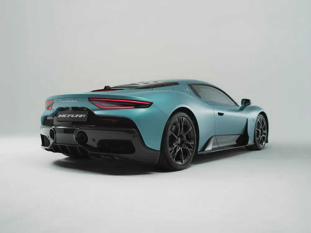 Blauwe Maserati MC20, achteraanzicht diagonaal, elegante aerodynamische en sportieve vormgeving.