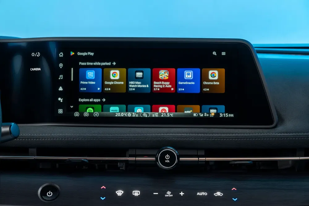 Tableau de bord moderne avec écran tactile affichant des applications Android Auto dans une voiture.