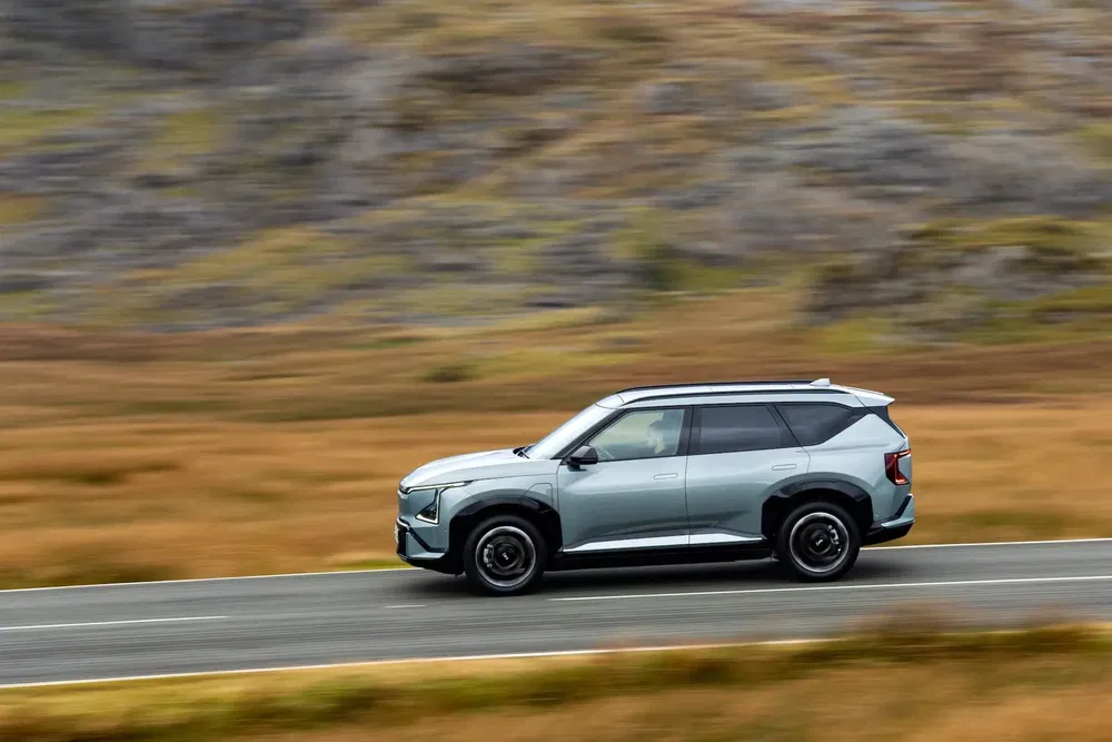 Moderne Aiways U5 SUV rijdt over een schilderachtige plattelandsweg.