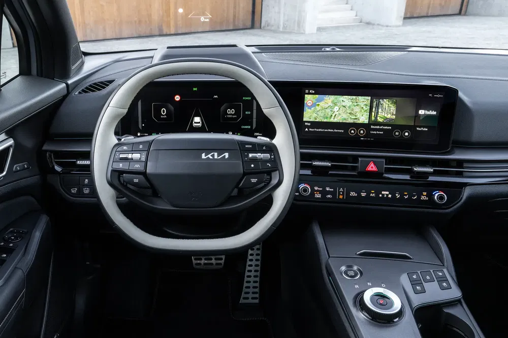Tableau de bord moderne d'une Kia avec écran tactile et volant multifonction.