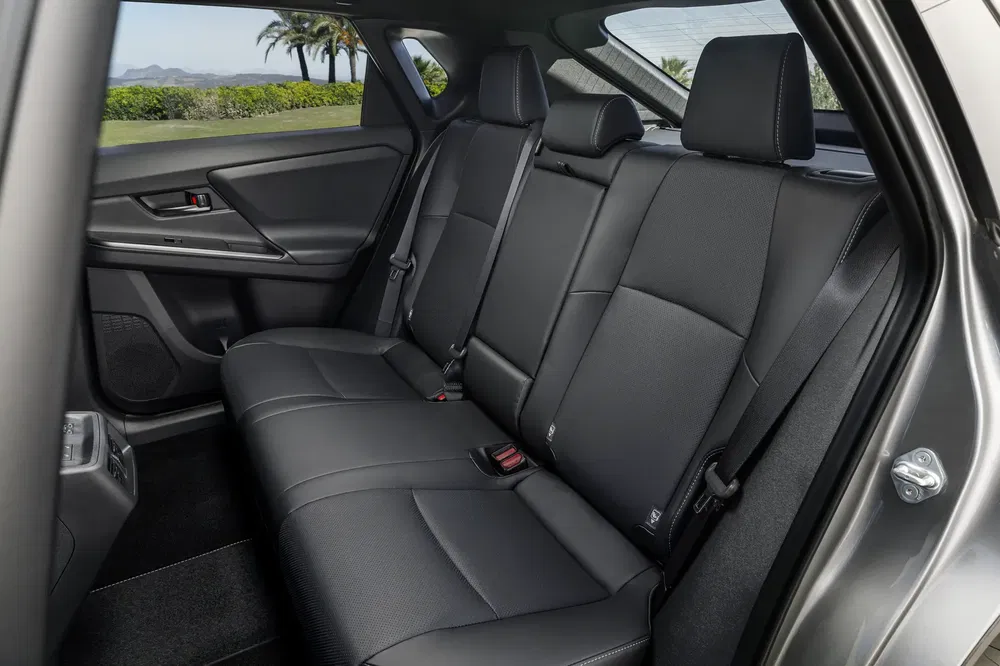 Ruim achterinterieur van SUV met zwarte lederen stoelen en zijarmleuningen.