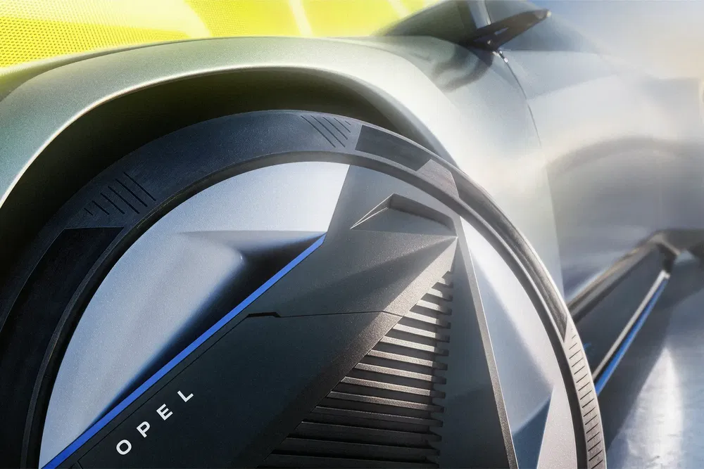 Détail avant futuriste de pneu Opel avec design aérodynamique et accent métallique bleu.