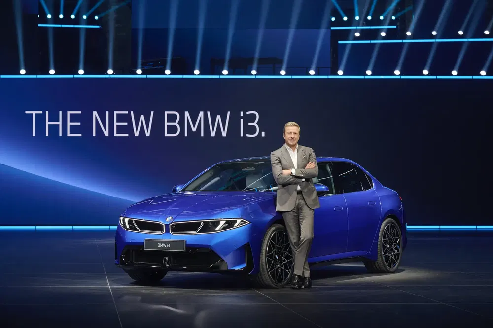 Présentation de la nouvelle BMW i3, berline électrique bleue sur scène éclairée.