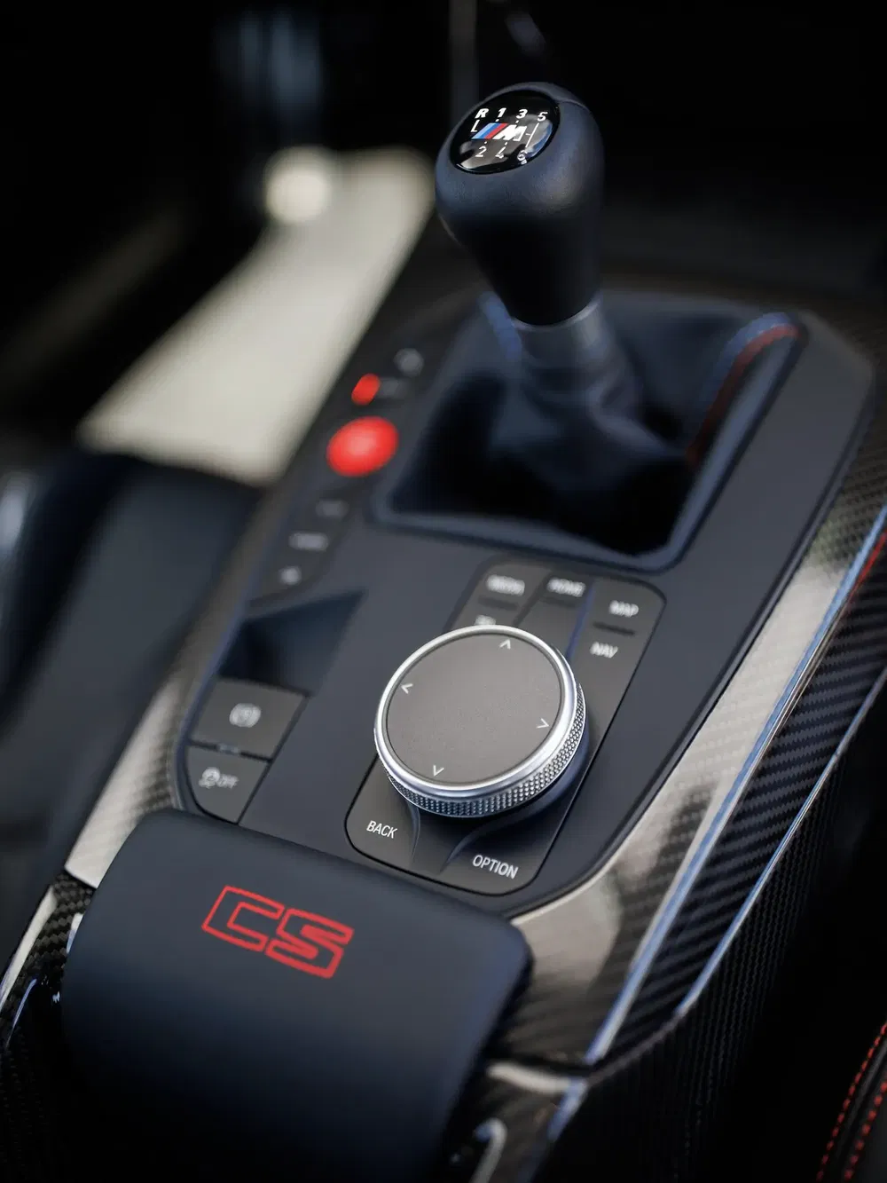 Interieur van BMW M met handgeschakelde versnellingspook en multimediabediening, stijlvol ontwerp.