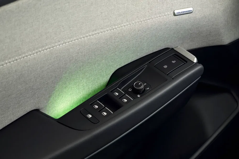 Porte intérieure Volkswagen avec commandes de fenêtre et éclairage vert élégant.