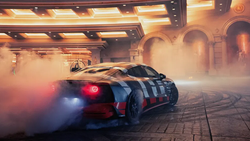 Voiture électrique Opel en drift à l'intérieur avec beaucoup de fumée entourée de lumières vives.