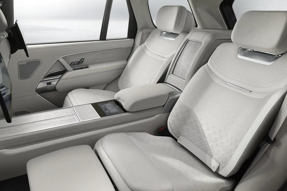 Luxe interieur sedan, witte leren achterstoelen met centrale armsteun en scherm.