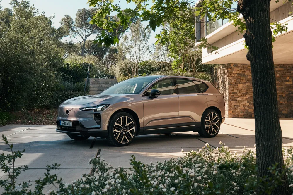SUV Zeekr X garé dans une allée moderne bordée de verdure.