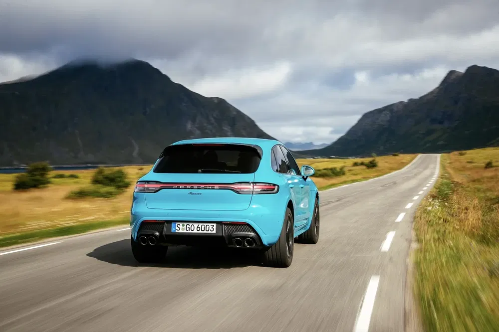 {"fr":"Porsche Macan bleu sur une route de campagne entourée de montagnes pittoresques.","nl":"Blauwe Porsche Macan op een landelijke weg omgeven door schilderachtige bergen."}