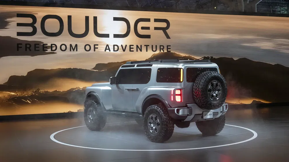 SUV Boulder exposé sur scène avec slogan 'Freedom of Adventure' en arrière-plan.