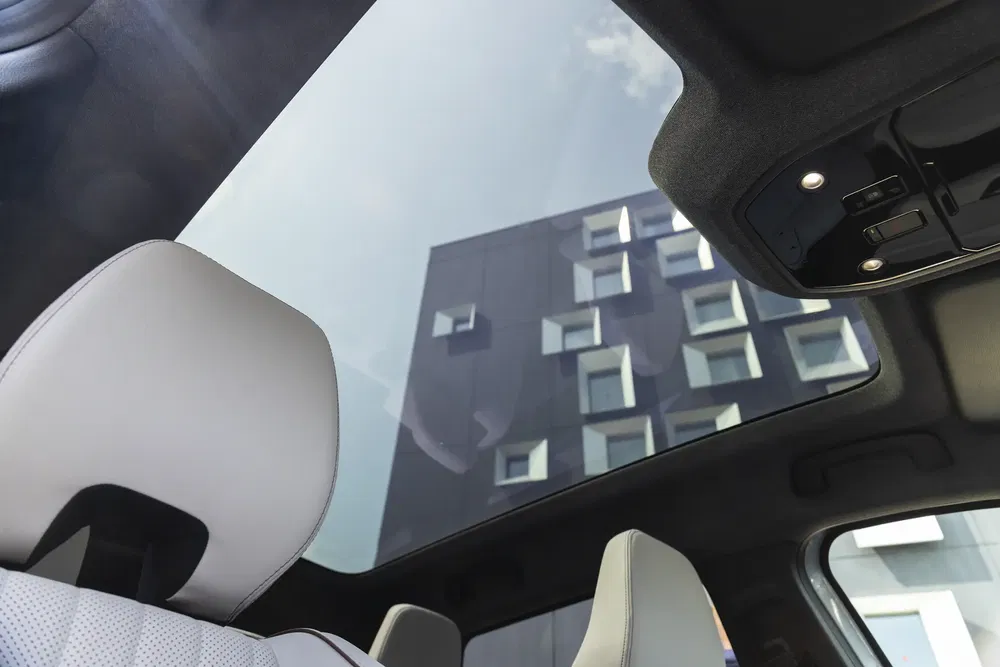 Vue intérieure d'un toit panoramique de voiture moderne avec bâtiment en arrière-plan.