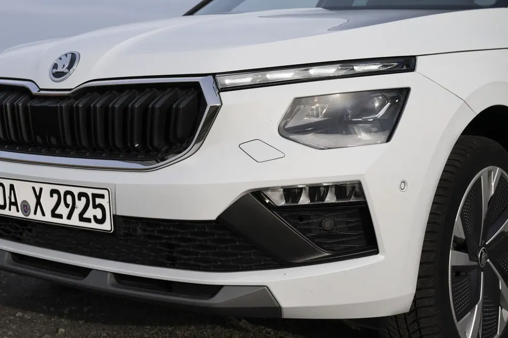 Voorkant van een witte Škoda met moderne koplampen en zichtbare kentekenplaat.