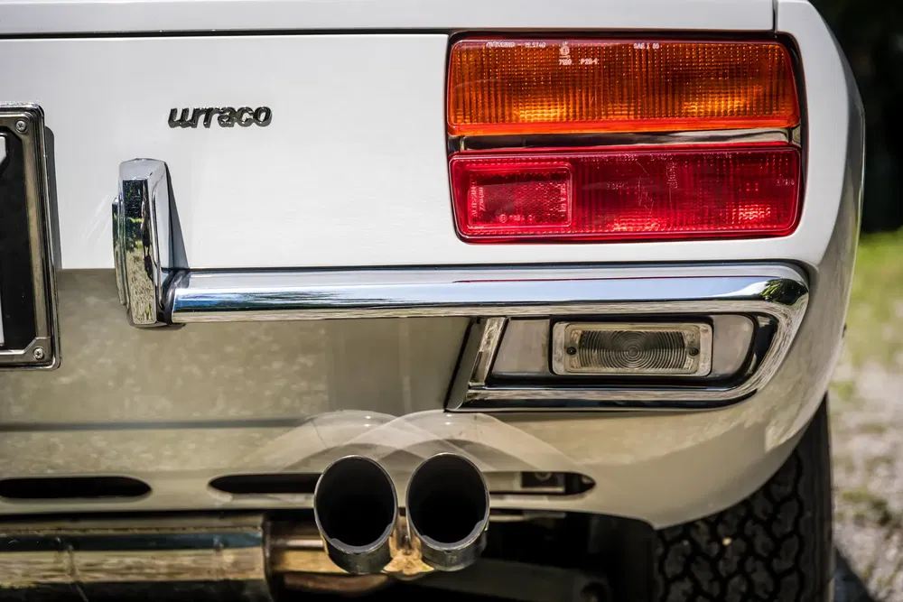 Detail van de achterlichten van een witte Lamborghini Urraco met dubbele chromen uitlaat.