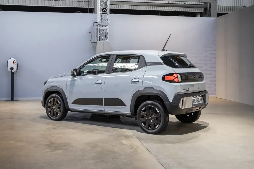 Grijze elektrische Dacia Spring SUV in een moderne garage, compact en robuust ontwerp.