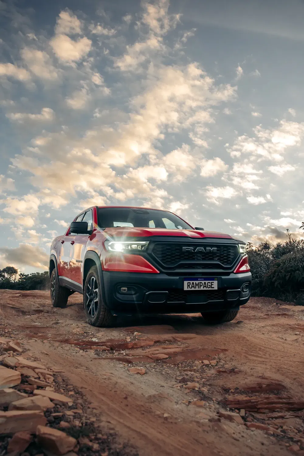 Rode RAM Rampage pick-up op onverharde weg onder bewolkte hemel.