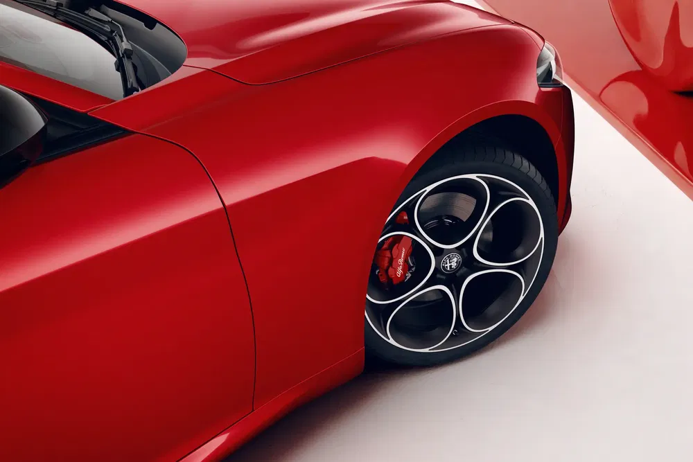 Détail d'une roue Alfa Romeo rouge avec étrier de frein distinctive.