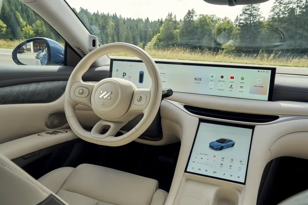 Intérieur d'une voiture électrique moderne avec grand écran tactile et volant élégant.