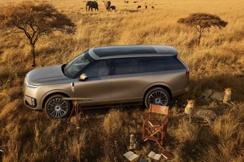 SUV Lincoln Navigator dans une savane africaine avec des éléphants et des guépards à proximité.