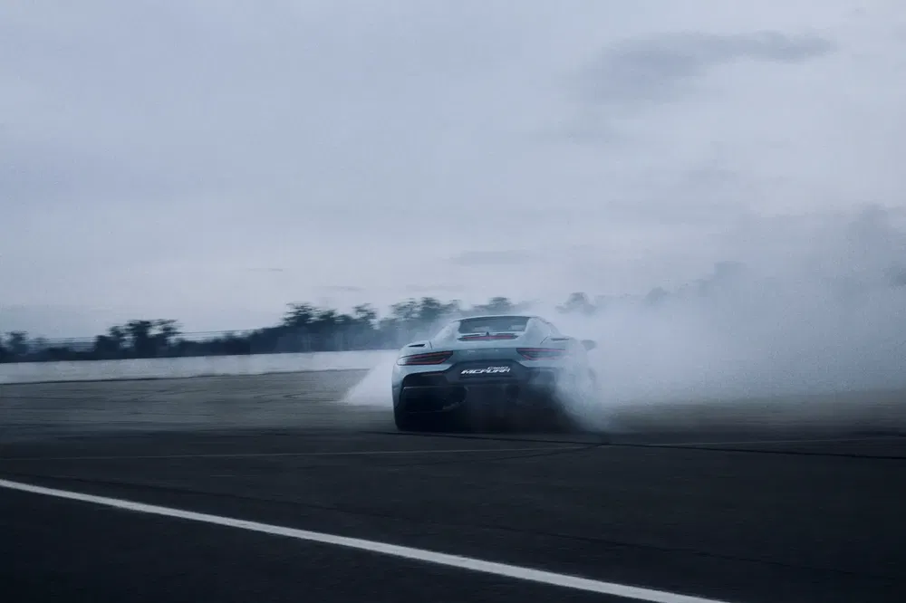 McLaren 570S maakt een drift met rook op een racecircuit.