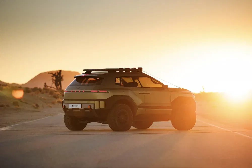 SUV tout-terrain futuriste traversant le désert au coucher du soleil.