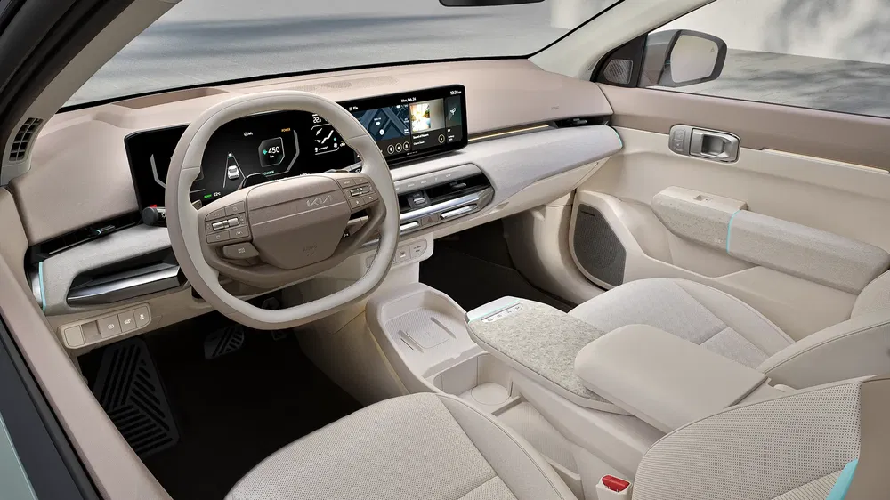 Intérieur moderne et élégant d'une Kia EV9 avec tableau de bord numérique et finitions beiges.