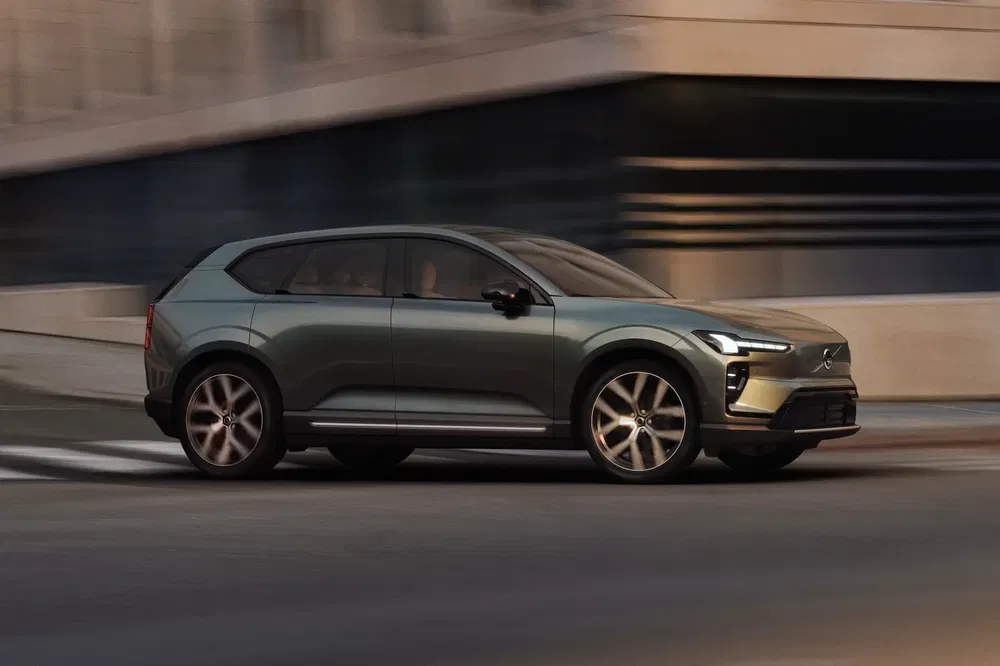 SUV électrique moderne Volvo EX90 roulant en milieu urbain au crépuscule.
