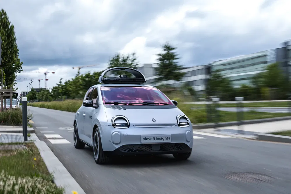 Renault électrique avec toit cargo roulant en zone urbaine.