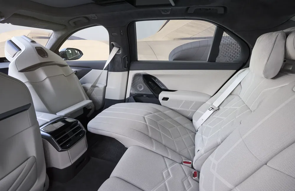 Luxe interieur van BMW i7 met ruime witte leren achterstoelen en moderne afwerking.
