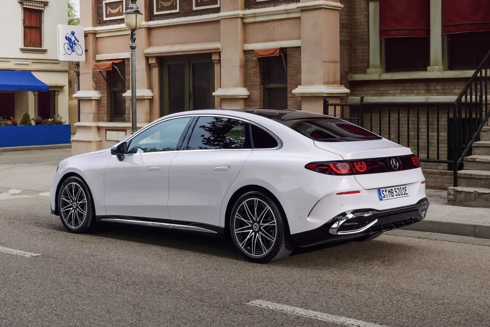 Mercedes-Benz EQE blanche garée dans une rue de ville, design élégant et moderne.